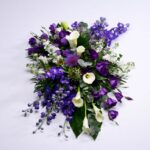Rouwarrangement wit paars calla delphinium